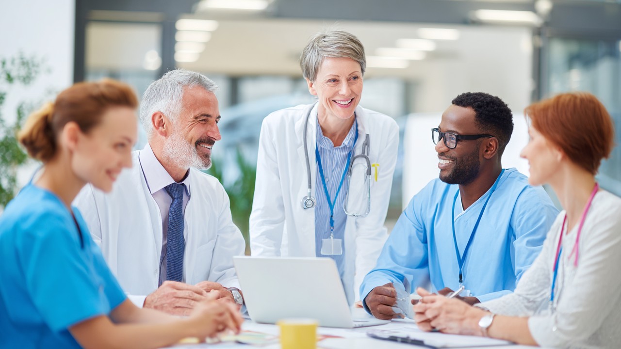 Diverse German patients consulting with a medical travel advisor in a modern clinic, discussing international healthcare options with brochures and a laptop.