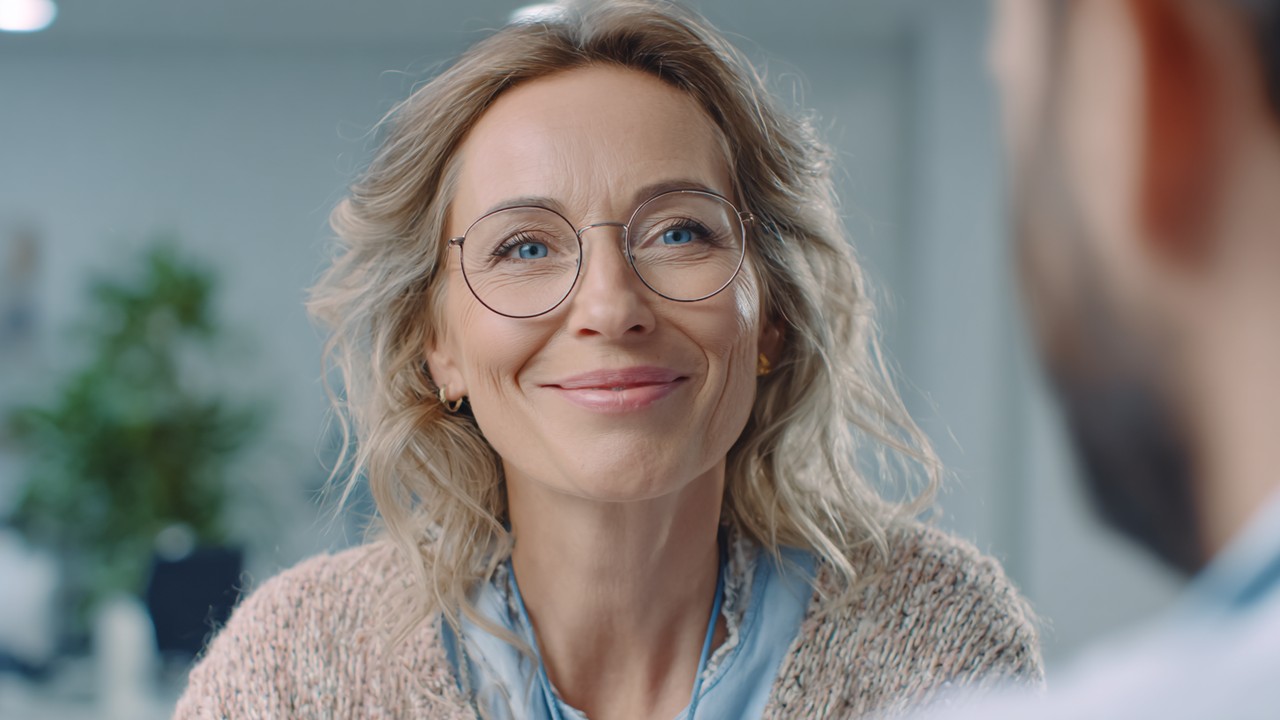German patient giving a heartfelt video testimonial in a well-lit clinic room, expressing trust and satisfaction with healthcare.