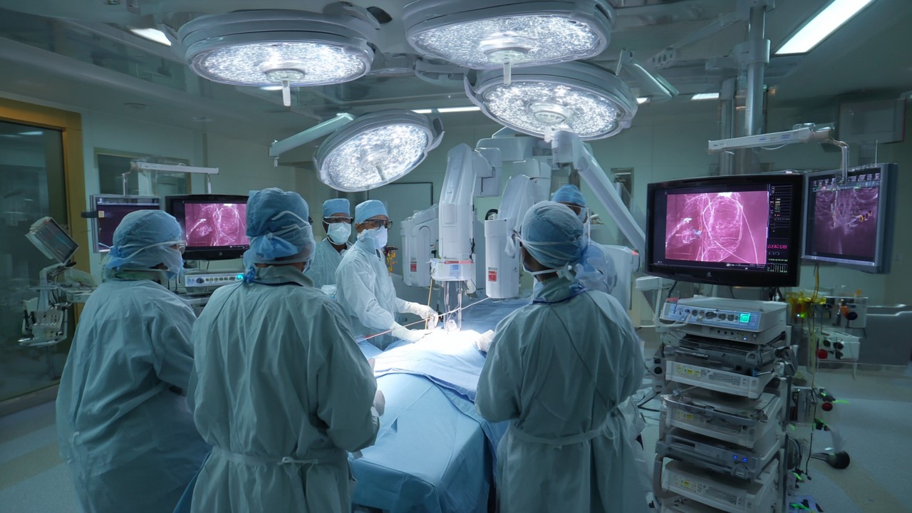 Medical professionals in specialized attire working with advanced robotic cardiac equipment and monitors in a high-tech Indian cardiac care room