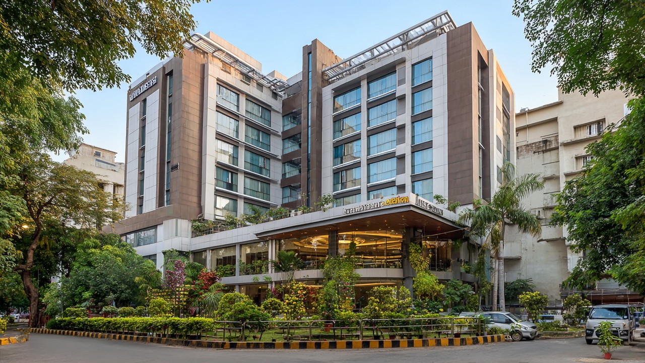 Gambar luar bangunan hospital ortopedi moden di India dengan tanda nama, dikelilingi tumbuhan hijau dan suasana mesra pesakit.