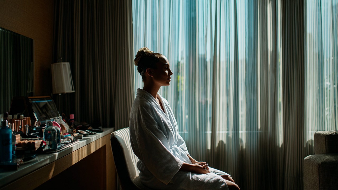 Person preparing for wellness procedure in a comfortable hotel room in Rio de Janeiro, with natural light and travel essentials visible.