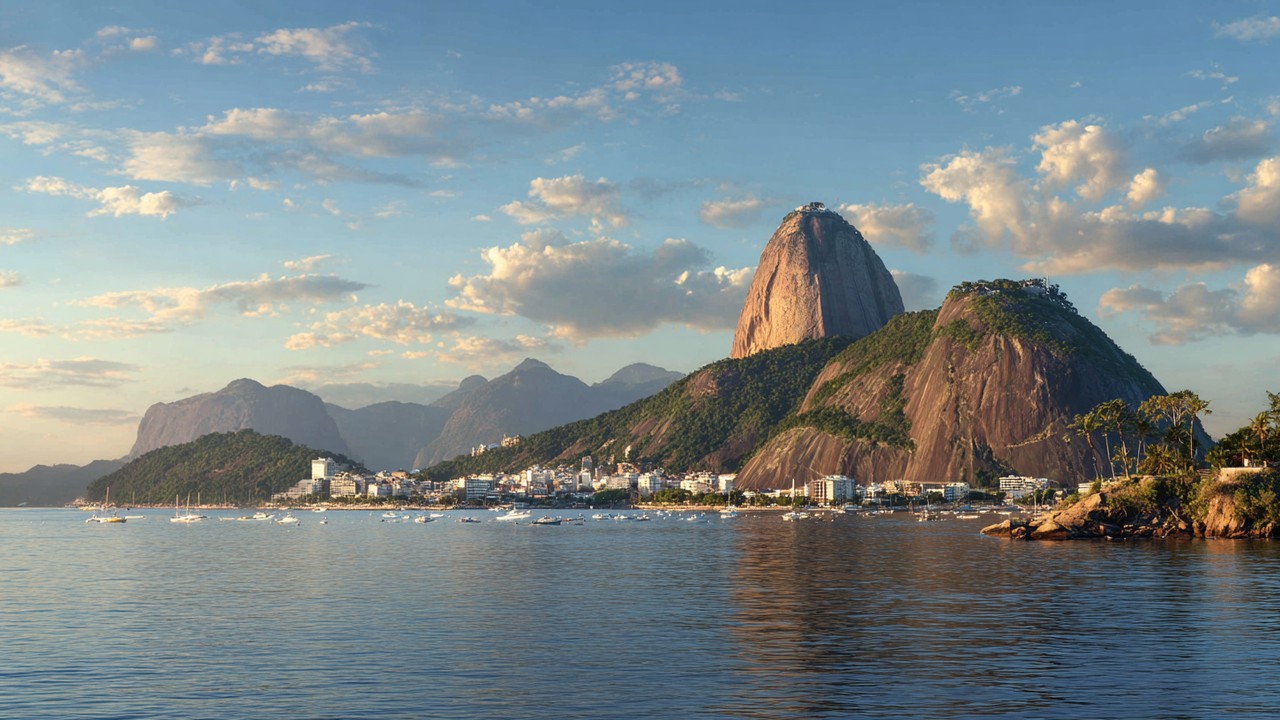 Serene Rio de Janeiro cityscape with Sugarloaf Mountain and Christ the Redeemer under changing weather, highlighting climate and tourism.
